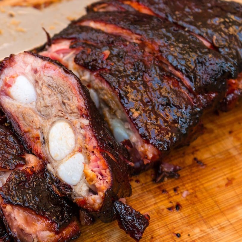 Close-up of Kenny's Ribs and Chicken's smoked ribs, sliced and showing tender meat and bones.