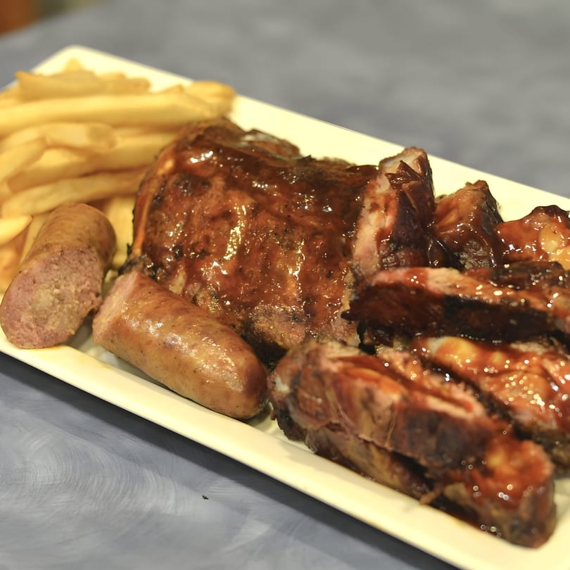 Kenny's Ribs and Chicken platter with BBQ ribs, sausage, and french fries.
